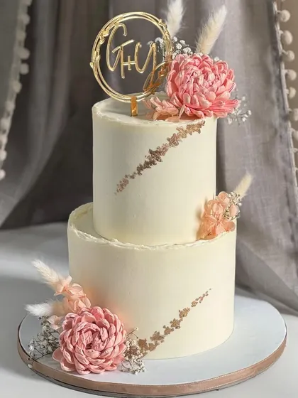 This two-tier boho floral cake is for celebrations that deserve a little extra grace. Hand-placed dried florals and textured buttercream create a design that feels warm, romantic, and beautifully understated.