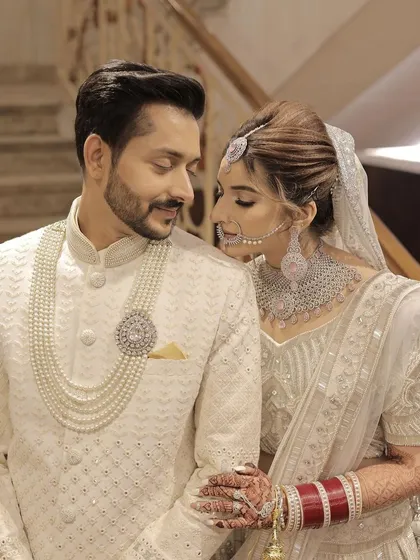 A classic portrait of the bride and groom, perfectly coordinated in their elegant white wedding attire. It was a pleasure creating this timeless look for her.