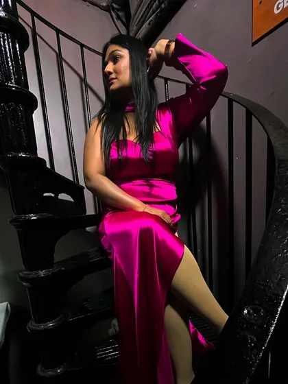 A striking pose in a satin pink dress. My style is confident and bold, just like my hosting.