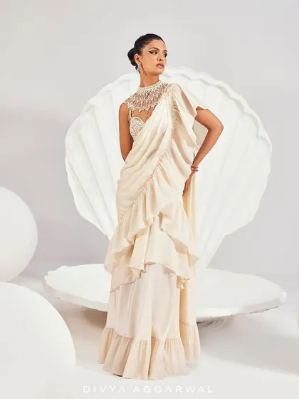 A full-length view of the Kairi Saree Set, showcasing the tiered ruffles and the stunning, embellished high-neck blouse against a pristine white backdrop.