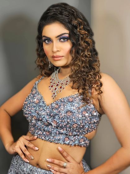 A powerful and confident pose showcasing a bold blue eye makeup look. This is for the woman who isn't afraid to stand out and make a statement.