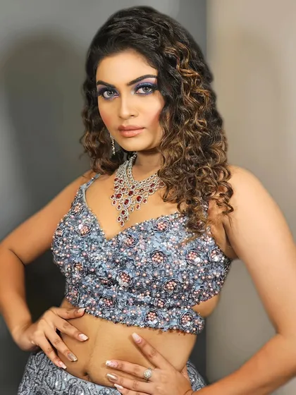 A bold and glamorous look with electric blue eyeshadow and curly hair. This is for a client who wants to stand out and make a statement.
