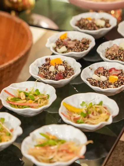 A selection of light and healthy salads, including quinoa salad and som tam salad, served in elegant, leaf-shaped bowls.