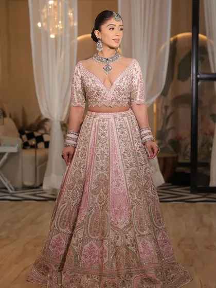 A full-length portrait of the bride in her modern pink lehenga. The confidence she exudes is what makes the outfit truly shine.