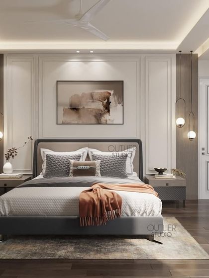 Transforming four walls into a haven of style. This bedroom features classic wall mouldings, warm wood accents, and a pop of burnt orange in the throw blanket, creating a timeless and inviting space.