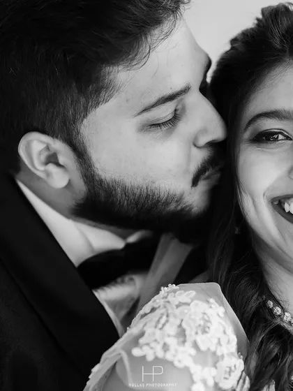 An intimate black and white close-up, capturing the groom's affectionate kiss.