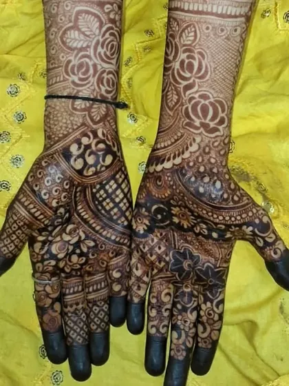 A dense design with a focus on rose motifs, covering the hands and wrists.