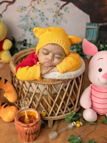 Our little Pooh Bear takes a nap in a rustic basket, complete with a "Hunny" pot. Themed newborn shoots are a wonderful way to add a touch of whimsy.