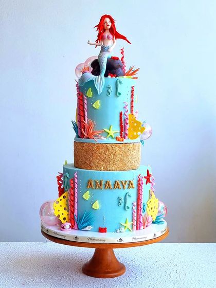 A full view of the Ariel-themed cake, showing its two tiers and colorful underwater details.