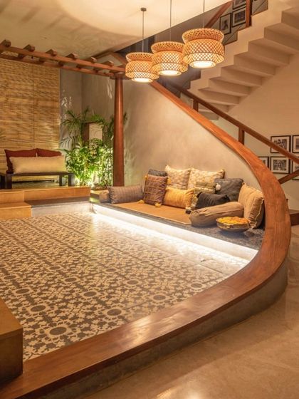 At night, the sunken seating area is transformed by concealed LED lighting along the curved wooden edge. This highlights the architectural form and creates a warm, inviting ambiance.
