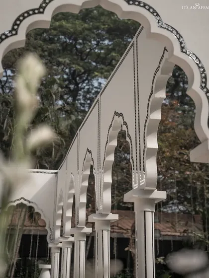An artistic shot through the pillars of the pavilion, highlighting the repeating arches and the detailed mirror inlay work.