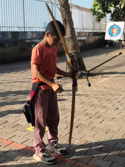 A young boy carefully nocking an arrow. We teach respect for the equipment and the sport from the very beginning.