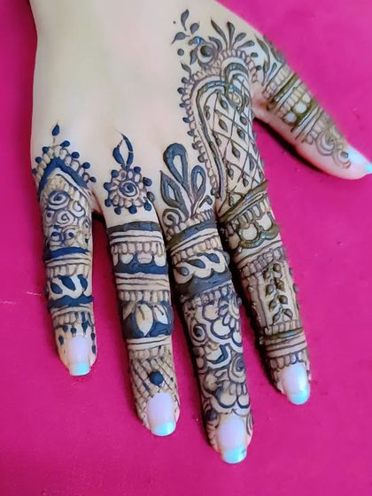 Another example of a stylish back-hand finger design, with each finger featuring a unique, complementary pattern.