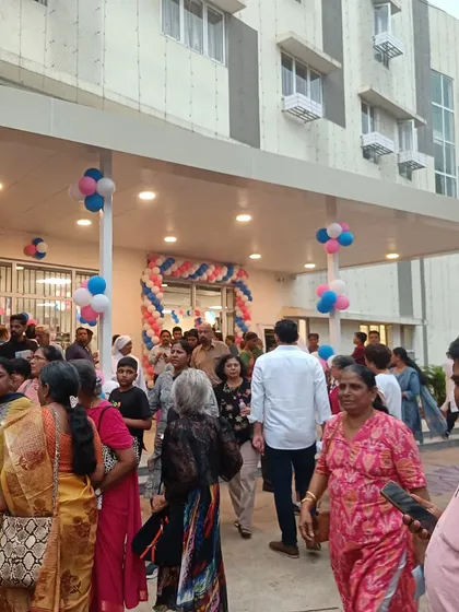 The entrance of the Home for the Aged, bustling with community members during its opening ceremony. The covered entryway provides a welcoming and accessible transition into the building for residents and visitors.