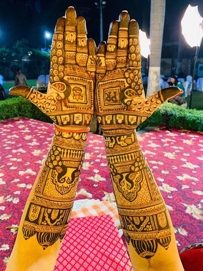 A beautiful shot of a traditional design with the couple's initials "PR" at a wedding event. The background shows the festive atmosphere where my art becomes a part of the celebration.