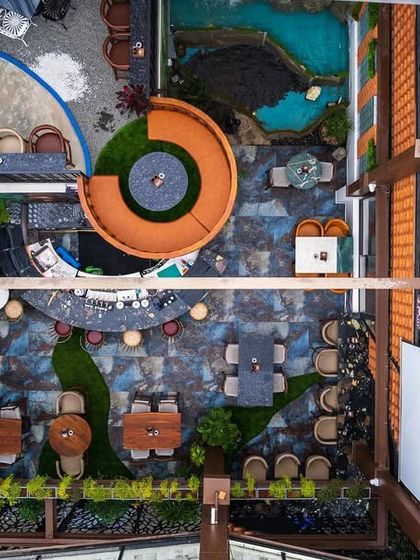 A top-down drone shot of the 'Highdrate' rooftop bar, revealing the intricate layout and the careful relationship between the built structures and natural elements like greenery and open sky.
