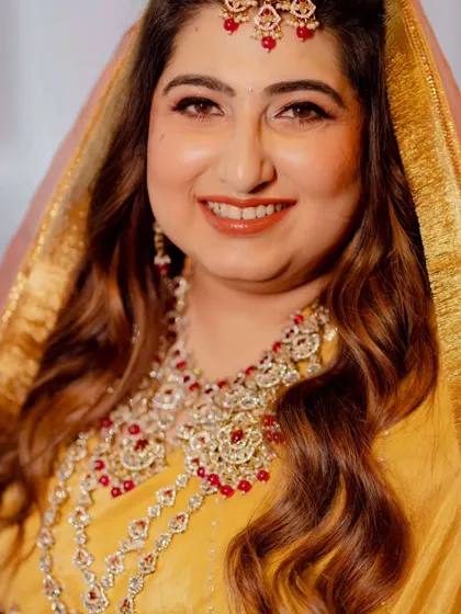 Capturing the joy of this bride's wedding ceremony. Her makeup is traditional and radiant, with warm tones and defined eyes, paired with soft waves for a look that is both classic and effortlessly beautiful.
