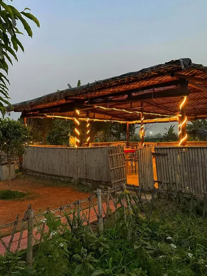 Our thatched-roof gazebo all lit up at dusk. It's a cozy spot for guests to sit and enjoy the peaceful farm ambiance during a sundowner party.