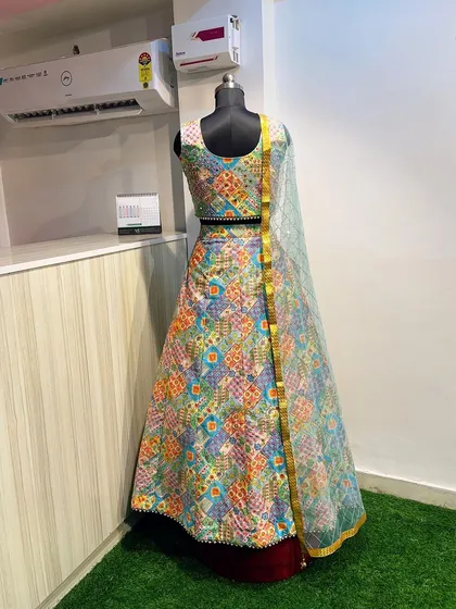 This multi-color printed lehenga is a fantastic option for a Mehendi function. The vibrant patchwork design and mirror-work blouse are festive and photogenic.