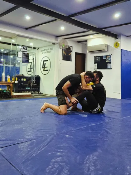 Two members drilling a guard pass. Repetition and practice are key to mastering any technique.