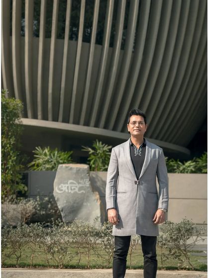 A portrait of me in front of my studio. The name 'Atrey' is carved into the stone, signifying the deep, personal connection I have with my work and my commitment to creating designs that are timeless and rooted in place.