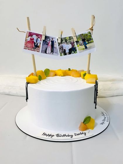 A really sweet cake for a dad's birthday. This design features a clothesline with printed family photos, turning memories into an edible decoration.