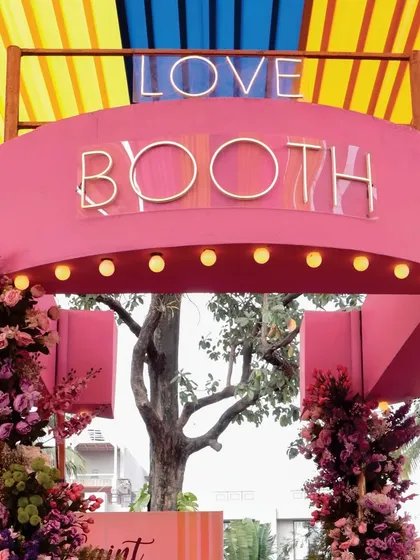A fun and stylish 'Love Booth' at the 'Spectrum of Love' Haldi, complete with neon-style lettering and bright lights for the perfect photo op.