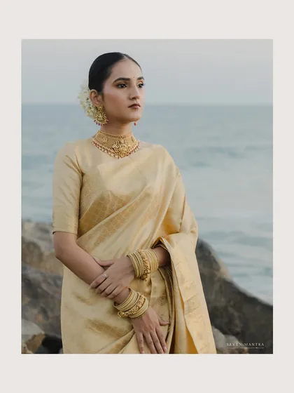 A classic bridal portrait by the sea. The bride's golden Kanjivaram saree glows in the soft light, her traditional jewelry and hairstyle completing a look of pure, timeless elegance that I helped curate.