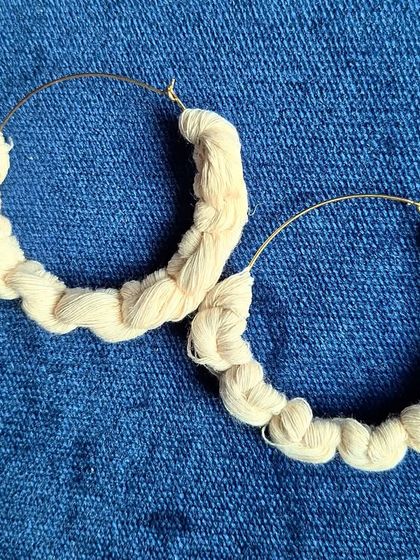 These simple and chic earrings are made by wrapping fiber around a hoop. The knotted texture gives them a subtle, handcrafted feel that is perfect for everyday wear.