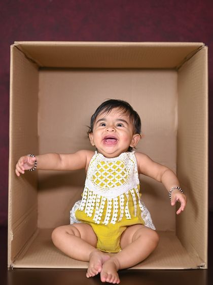 The crying face! Even the tears are a precious memory to look back on. This 'baby in a box' shot captures a real, unfiltered moment.