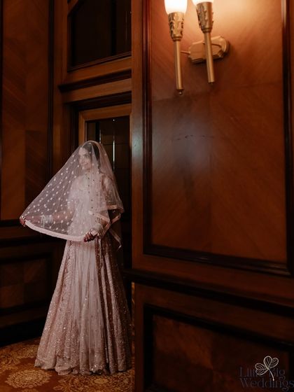 A beautiful bridal portrait in a warmly lit corridor, her veil adding a touch of mystery and elegance.