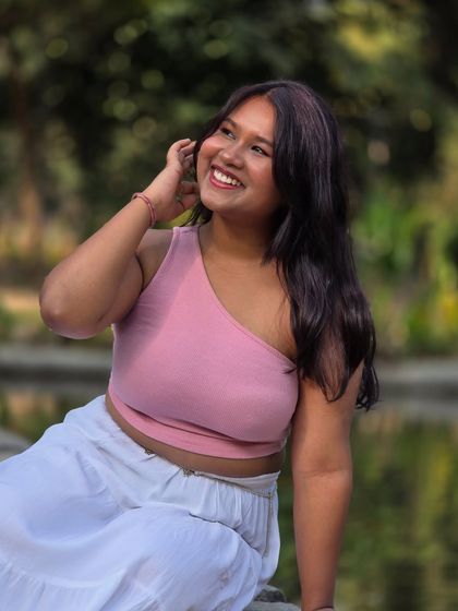 A happy, sunlit portrait taken in a park. Her joyful laugh and the beautiful natural light create a warm and inviting image, perfect for a lifestyle shoot.