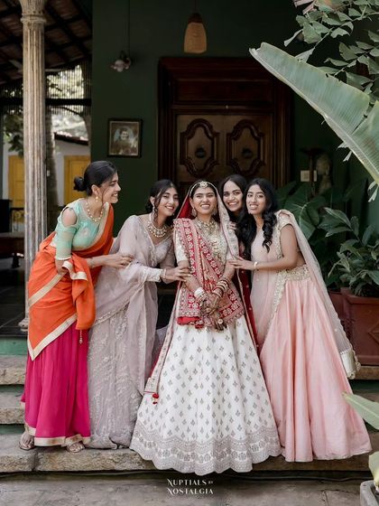 A bride shares a laugh with her bridesmaids on the steps of one of our heritage buildings.