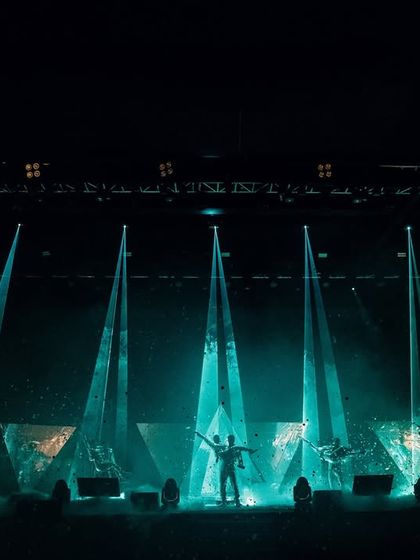 A wide-angle view of our laser-programmed couple entry. This shot captures the immense scale of the production, with towering light beams creating a cathedral of light for the couple.