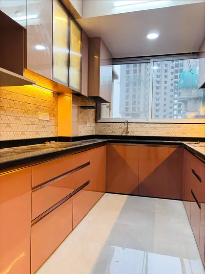 A perspective shot of the U-shaped kitchen, showing the large window that brings in natural light, complementing the interior lighting scheme.