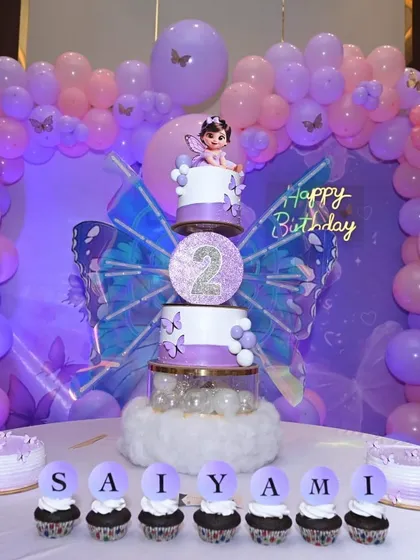Personalized cupcakes spelling out "SAIYAMI" for her butterfly-themed birthday party.