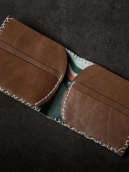 The interior of a custom leather wallet, showing the card slots and fine stitching details taught in our basics of leather craftsmanship workshop.