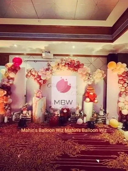 A full view of a teddy bear-themed stage, framed by a beautiful balloon arch in warm, rustic colors.