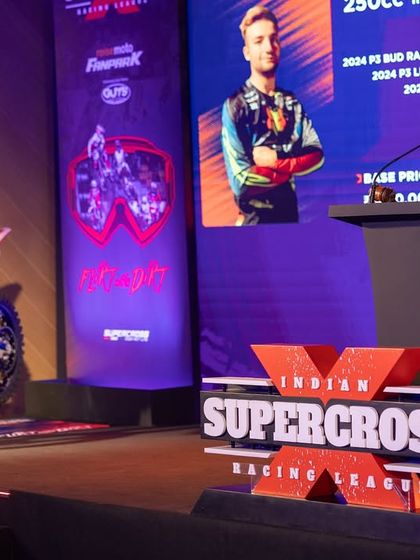 The auctioneer on stage at the ISRL Auction, with a race bike on display. We produced the entire live auction event, from stage design to the technical backbone.