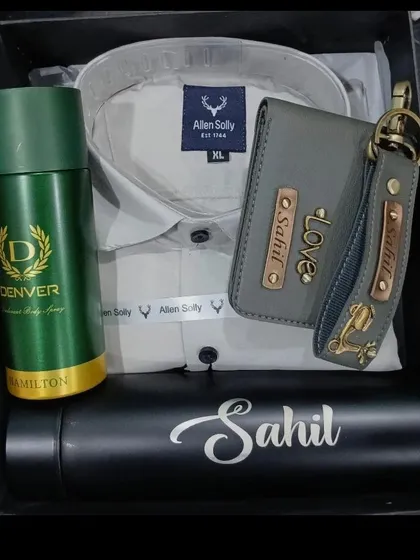 This elegant gift hamper features a personalized wallet, keychain, and temperature bottle, along with a light grey shirt and deodorant.