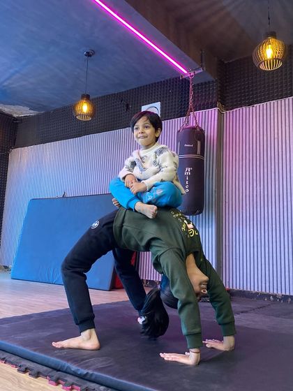 We sometimes incorporate partner exercises to make conditioning more fun and effective. Here, one student holds a strong bridge while another balances on top, building trust and stability.