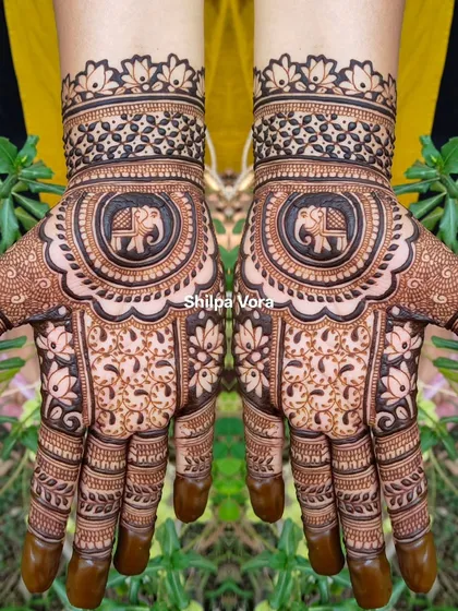 A traditional design with a central elephant mandala, surrounded by delicate floral and leaf patterns.