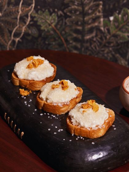Cheeni Malai Toast, our take on a nostalgic classic. Creamy, lightly sweetened malai on crisp toast, topped with honeycomb candy, makes for a delightful and unique appetizer or snack for your event.