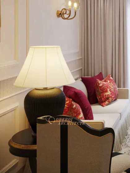 Layered lighting is key to creating ambiance. Here, a classic table lamp, wall sconce, and overhead chandelier work together to provide warm, balanced light in this elegant drawing room.