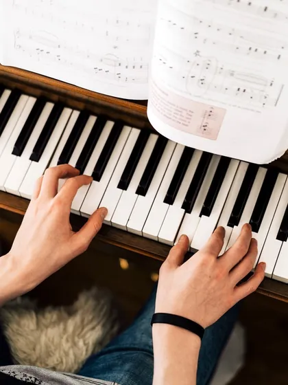 This image captures a student deeply focused on their sheet music while playing the piano. I place a strong emphasis on music literacy, ensuring you can confidently read and interpret musical scores as part of your training.