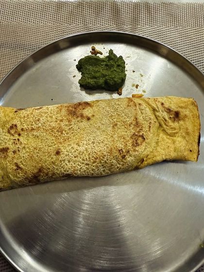 A besan cheela (gram flour pancake) served with green chutney. This is a high-protein, gluten-free option that is great for weight loss.