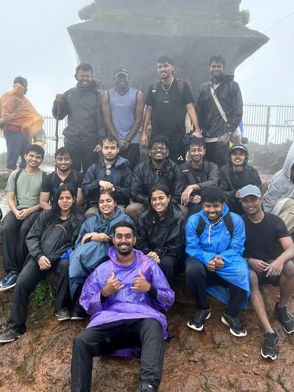 At a foggy summit, this group huddles together, celebrating their climb. The shared challenge and victory create a special camaraderie that defines our trekking community.