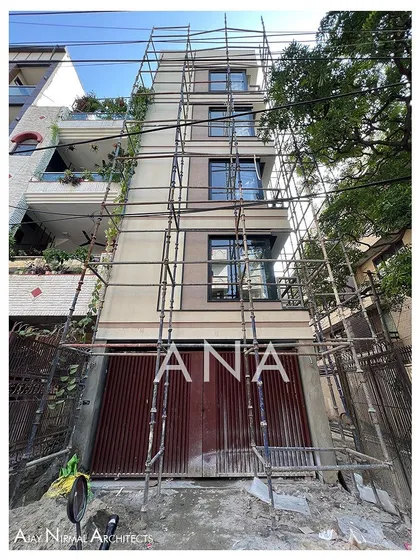 The Yellow Line Apartment during the facade finishing stage, with scaffolding still in place. This shows the process of applying the final textures and colors to the building.