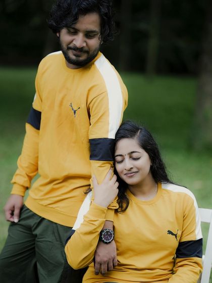 A tender moment, with the bride-to-be resting her head on her partner's arm, her eyes closed in contentment.