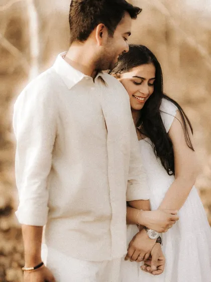 A close-up shot filled with warmth and genuine smiles. This candid portrait captures the couple's comfortable embrace and the joy they find in each other's company.